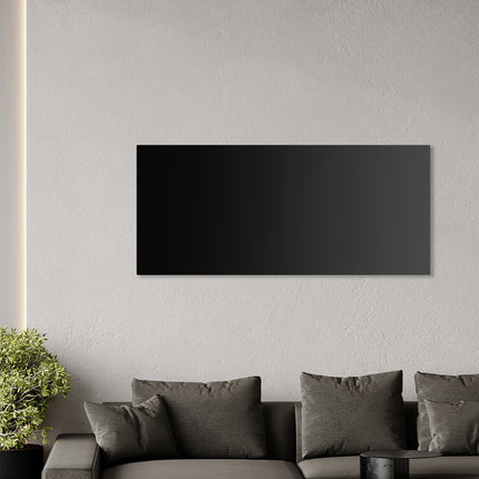 Hermoso panel infrarrojo de vidrio negro en la pared sobre un sofá gris, solución de calefacción elegante y eficiente para la sala de estar.