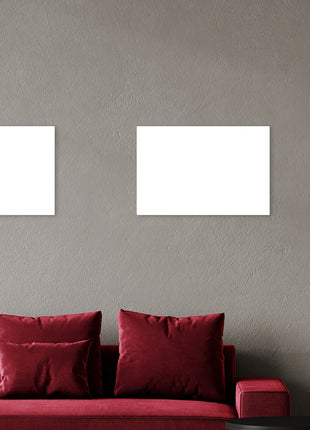 Rode sofa met daarboven twee 600 watt infrarood panelen aan de muur, stijlvolle en efficiënte verwarmingsoplossing voor de woonkamer.
