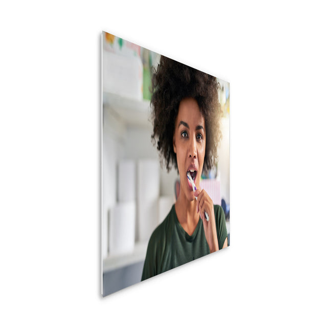 400 watt ECAROS infrared mirror with the reflection of a woman brushing her teeth, efficient and stylish heating solution for the bathroom.